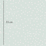 a green background with white polka dots
