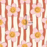 a repeating pattern of pink and white flowers with smiling faces, and there is a measurement line indicating the size of the flowers.