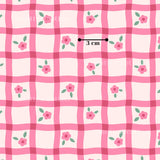 a repeating pattern of pink and white checkered squares with pink flowers and green leaves.