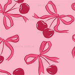 a pattern of cherries with a bow on a pink background