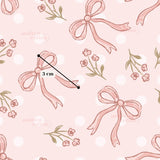 a repeating pattern of pink bows and flowers on a pink background with white polka dots.