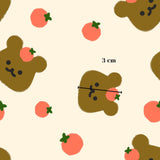 a repeating pattern of brown bear faces with orange spots and green leaves, along with small orange circles scattered throughout the background.