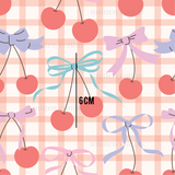 a pattern of cherries and bows on a gingham background