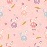 a repeating pattern of smiling rabbit faces and carrots against a pink background, with the size of the rabbit faces being 2.5 cm in size.