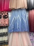 a variety of colorful tulle skirts and dresses arranged on a wire rack.