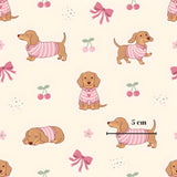 a repeating pattern of cartoon-style dachshunds wearing pink sweaters, with cherries and bows scattered throughout the background.