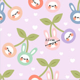 a repeating pattern of cartoon rabbit faces and cherry blossoms against a pink background.