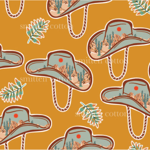 a pattern of cowboy hats and cactus plants on an orange background