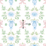 The image is a repeating pattern of blue flowers with green leaves and pink bows, with a measurement line indicating the size of the pattern.