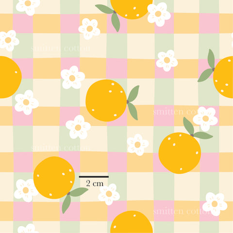 a pattern of oranges on a checkered tablecloth