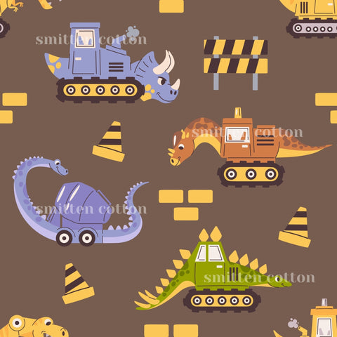 a repeating pattern of various cartoon-style construction vehicles and dinosaurs, including bulldozers, excavators, and triceratops, all set against a brown background with yellow and black accents.