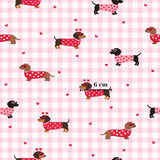 a repeating pattern of dachshund dogs wearing red heart-shaped sweaters against a pink and white checkered background.