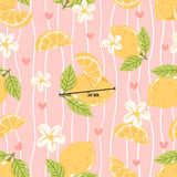 a repeating pattern of lemon slices, flowers, and leaves on a pink background.