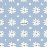 a pattern of white daisies with green centers, all set against a light blue background with scattered white dots. The image is approximately 1.5 cm in size.
