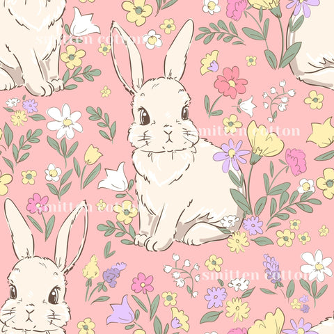 a pattern of cartoon rabbits surrounded by colorful flowers and leaves on a pink background.