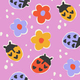 a playful arrangement of colorful ladybug illustrations on a pink background, with scattered white dots.